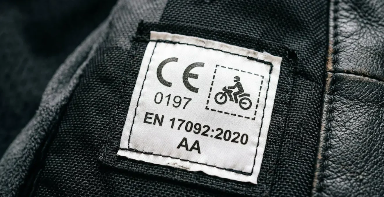 Nahaufnahme eines CE-Etiketts an Motorradbekleidung mit Schutzklasse-Kennzeichnung und Prüfnummer