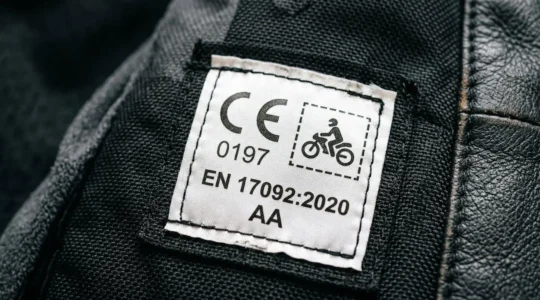 Nahaufnahme eines CE-Etiketts an Motorradbekleidung mit Schutzklasse-Kennzeichnung und Prüfnummer