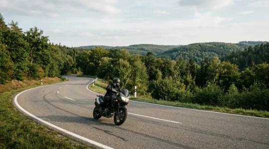 Motorradfahrer in kontrollierter Schräglage auf kurviger Landstraße bei optimalen Bedingungen