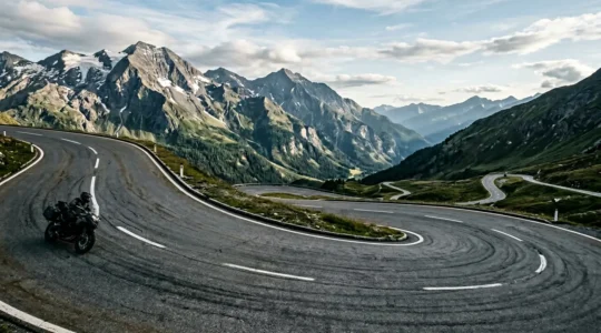 Motorradfahrer in dynamischer Schräglage auf kurviger Landstraße mit physikalischen Kräften visualisiert