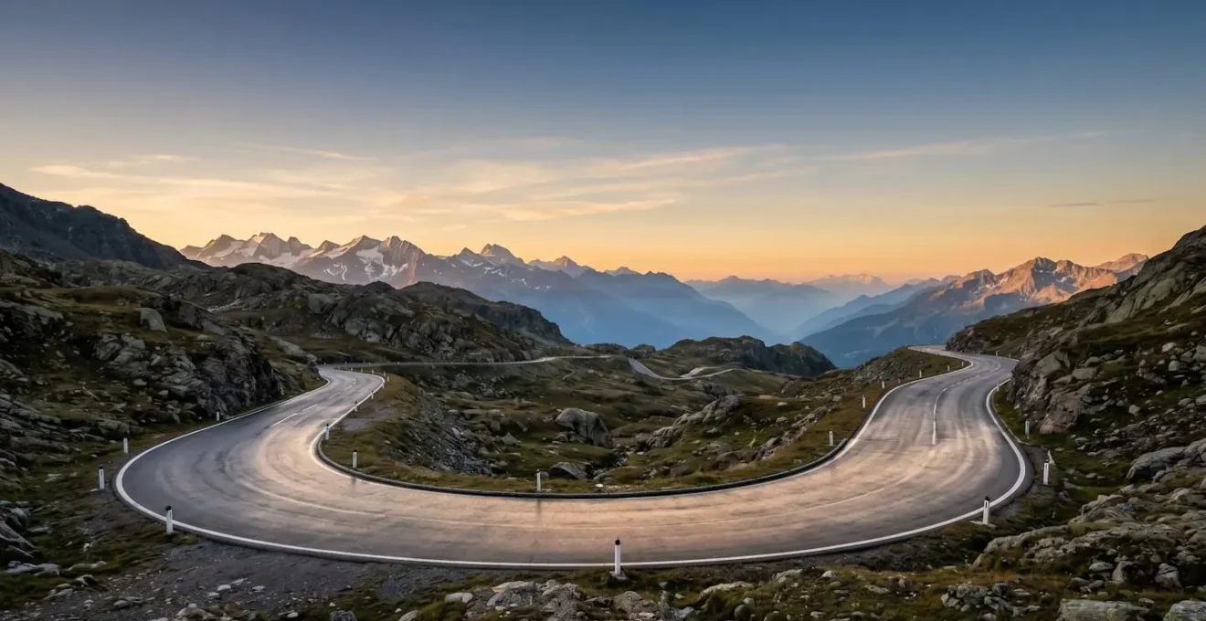 Frühmorgendliche Lichtstimmung an einer alpinen Passhöhe mit klarer Sicht und leerer Strasse