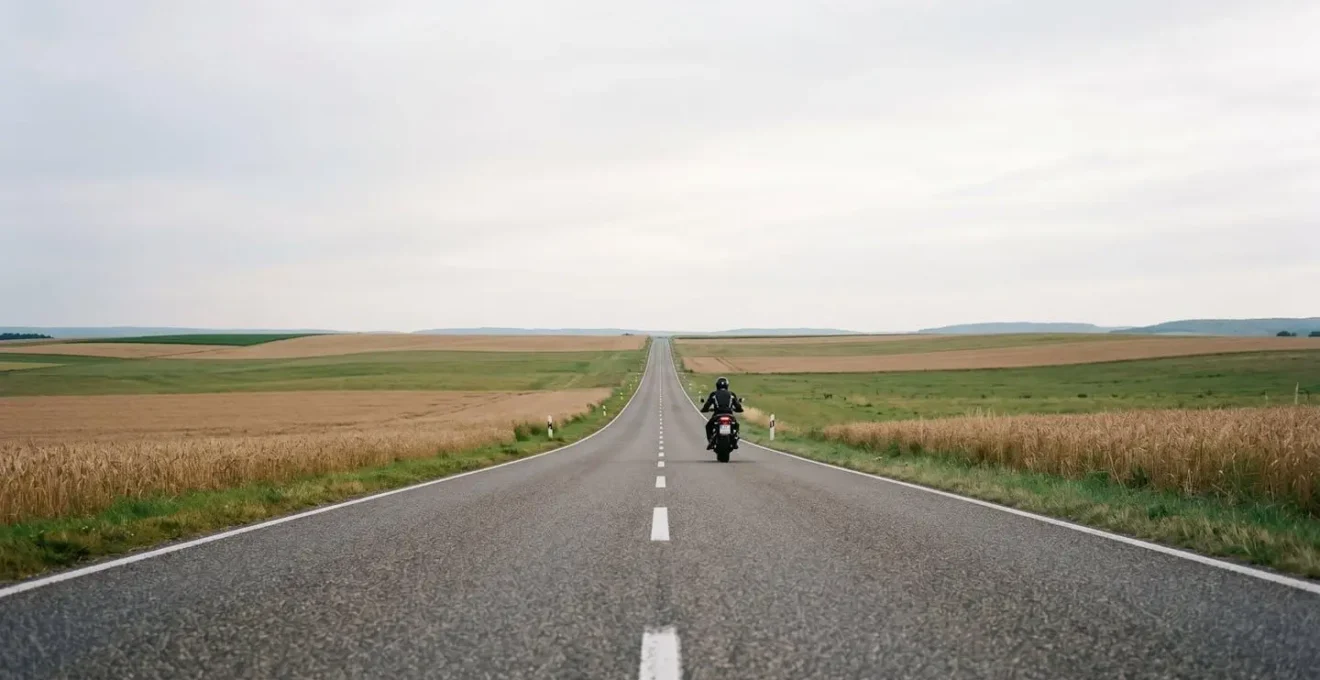 Motorradfahrer in ruhiger Fahrhaltung auf leerer deutscher Landstrasse die Ruhe und Konzentration ausstrahlt