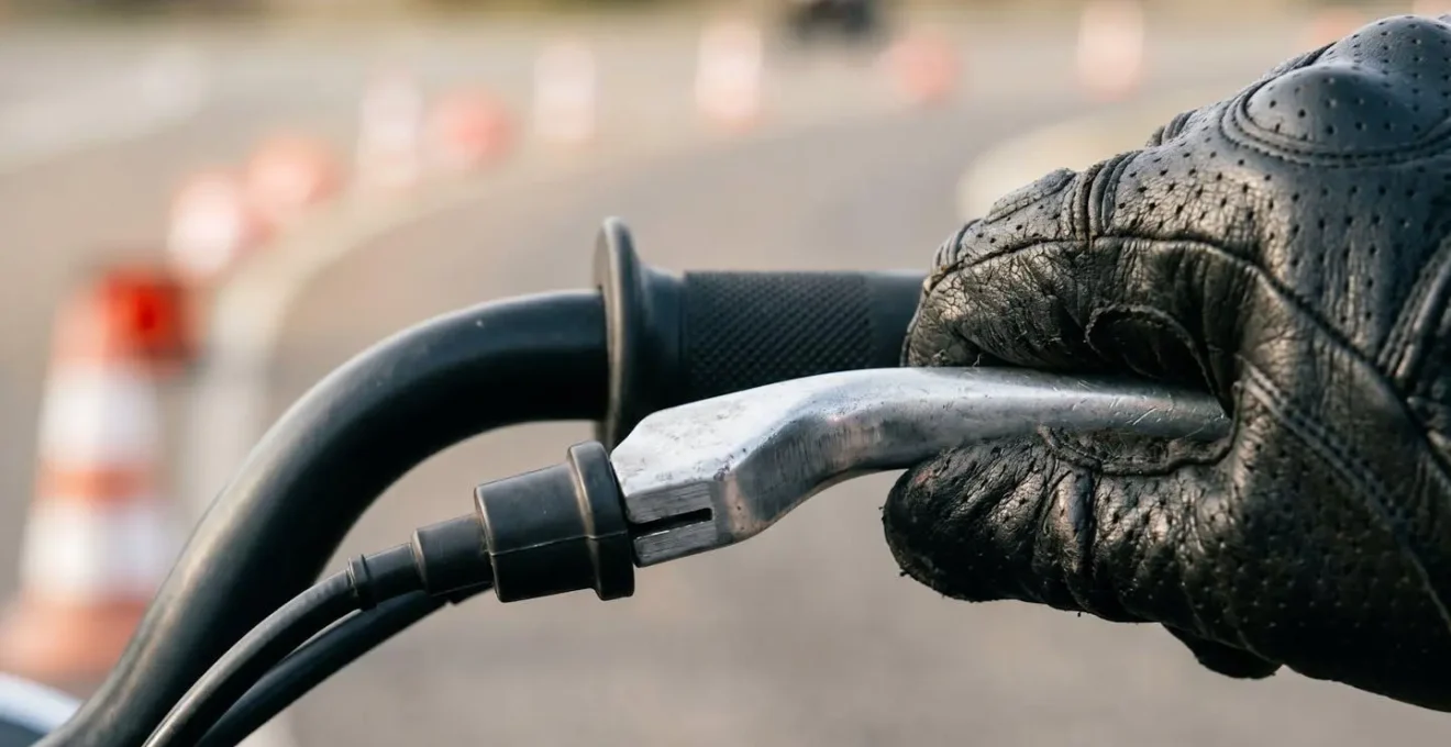 Detailaufnahme der Handbremstechnik eines Motorradfahrers beim Kurveneingang auf einem Übungsplatz